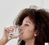 Kvinde som drikker mundskyld mod blister i halsen