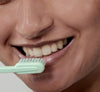 Kvinde med tandbørste som smiler