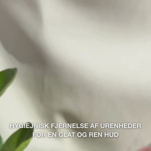 Video i close-up af hænder, der bruger et dobbeltsidet rustfrit stål-hudormeværktøj i ansigtet: en lille metal-løkke placeres forsigtigt omkring en hudorm på næsen, derefter tørres talg og urenheder væk, værktøjet skylles, og en beroligende tonic og ansigtscreme påføres.