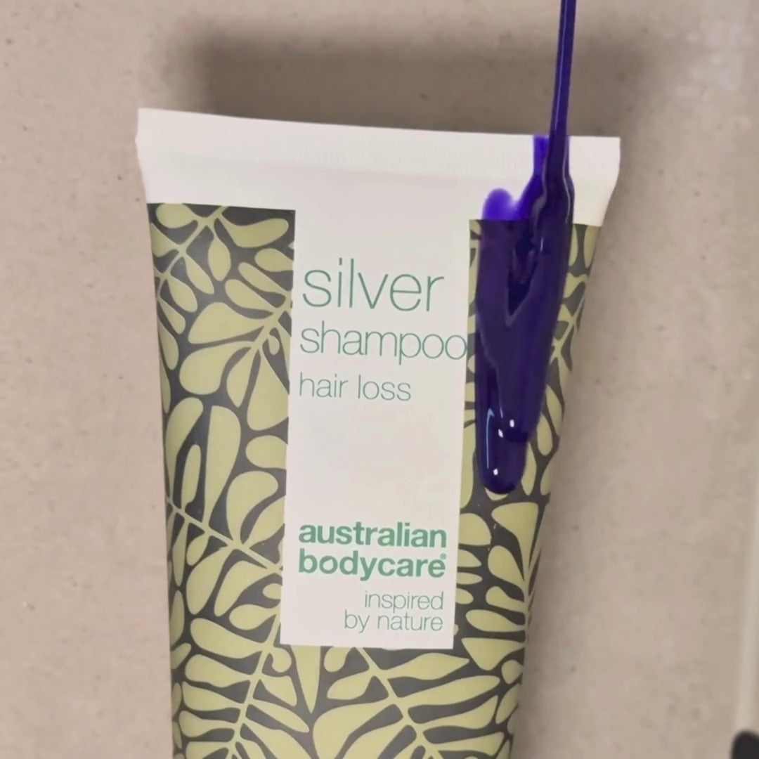 Video, der viser vores Hair Loss Silver Shampoo med sølv-lilla farve blive påført vådt hår i badet.