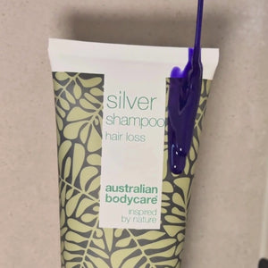 Video, der viser vores Hair Loss Silver Shampoo med sølv-lilla farve blive påført vådt hår i badet.