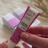 Video: en hånd holder en tube B12 Lip Balm fra Australian Bodycare ved siden af æskerne.